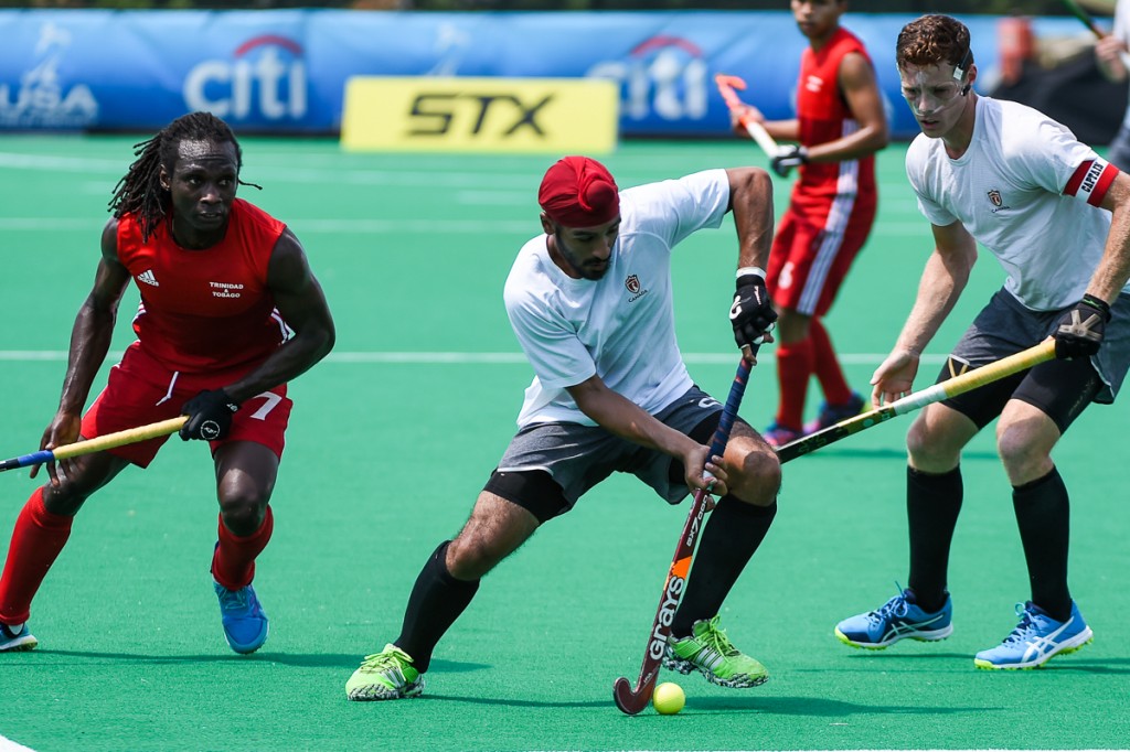 PHOTO: Harbir Sidhu (centre) carries the ball out of danger while playing Trinidad Tobago at the 2017 Pan American Cup on August 4 in Lancaster, USA. (by Yan Huckendubler/PAHF)